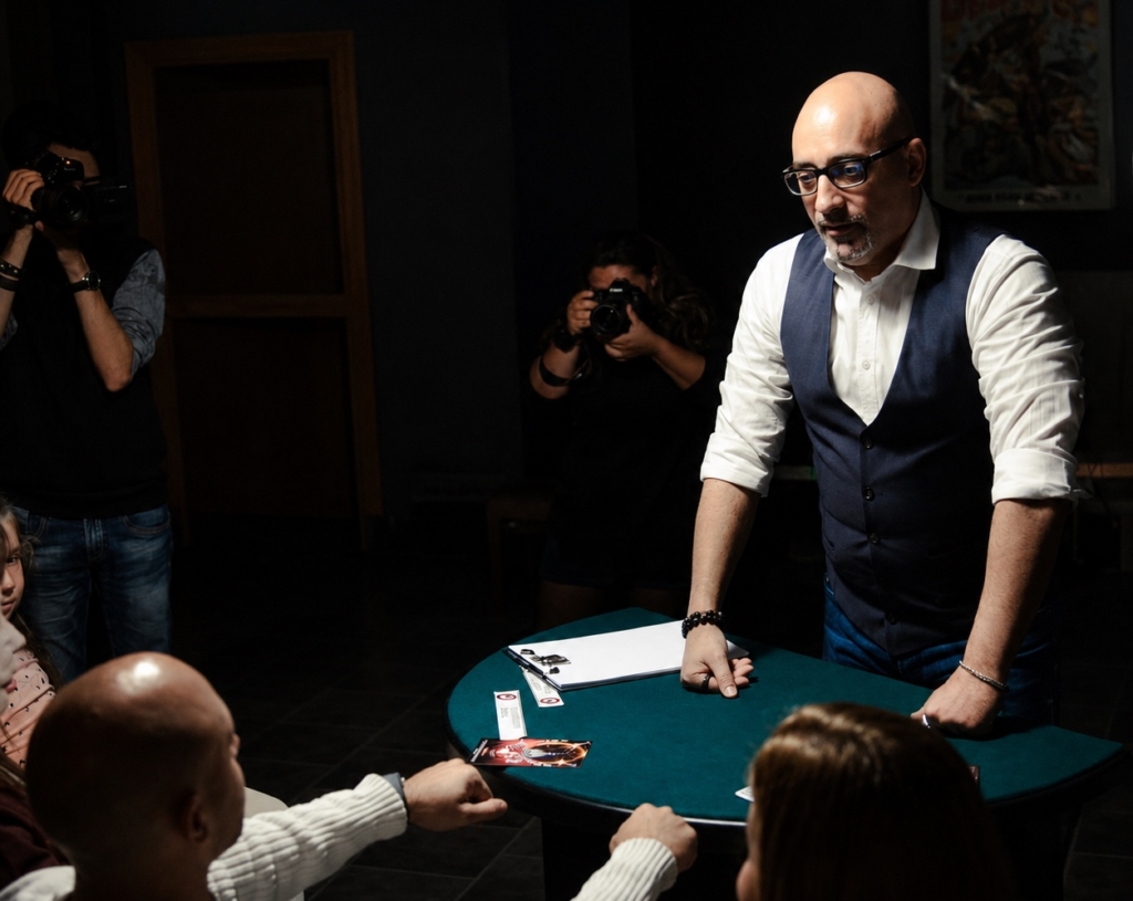 Antonio Argus mentalista di fronte a uno spettatore con un oggetto in mano, mentre studia la psicologia della percezione durante una performance